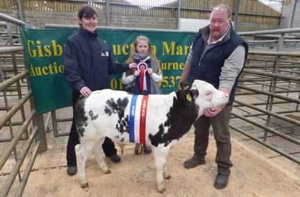 Isabel Gardner of Genus Breeding presenting Anna & Doug Graves their champion rosette with their British Bull calf which sold for £490