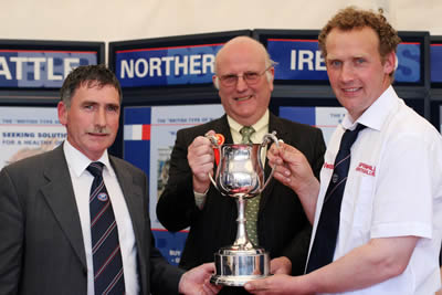 Harold McKee, Secretary, NI Blue Cattle Club and Con Williamson, Judge of the Balmoral Show Blue classes present an award to James Martin for Martin Brothers Best Senior Blue Heifer.